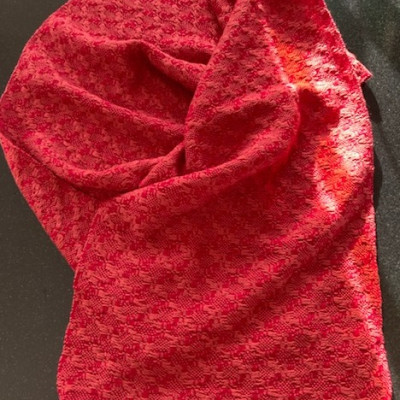 A red and pink woven shawl.