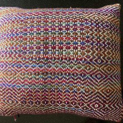 A brightly coloured cushion with various patterns