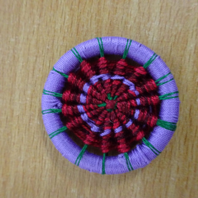 A purple, red and green Dorset Button